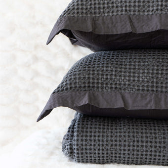 Quilt tipo waffle color gris doblado, ideal para capas ligeras

