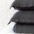 Quilt tipo waffle color gris doblado, ideal para capas ligeras

