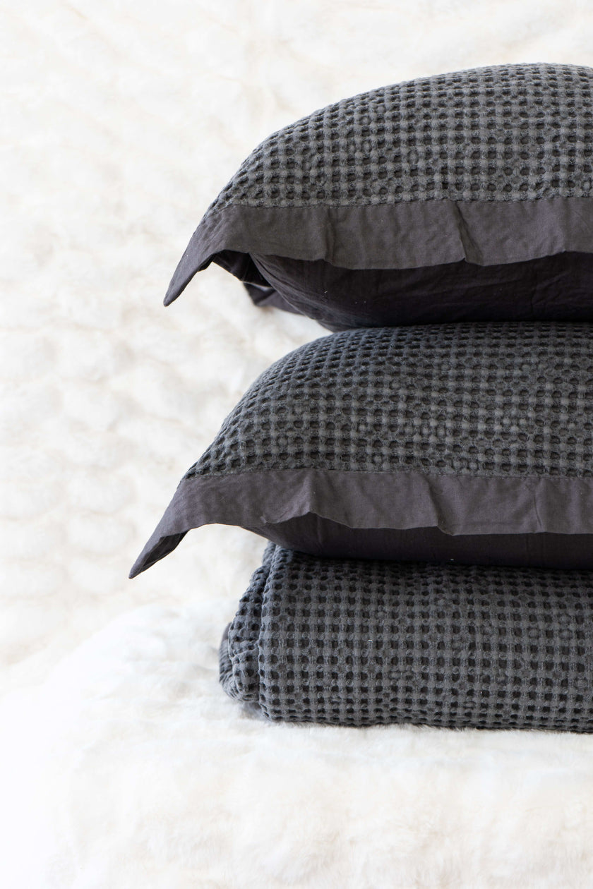 Quilt tipo waffle color gris doblado, ideal para capas ligeras


