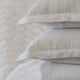 Quilt tipo waffle color blanco doblado, ideal para capas ligeras
