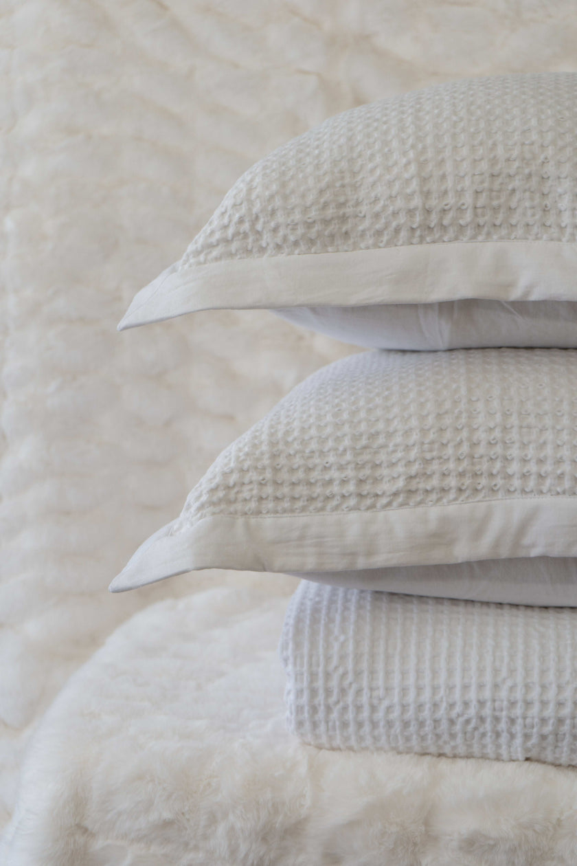 Quilt tipo waffle color blanco doblado, ideal para capas ligeras
