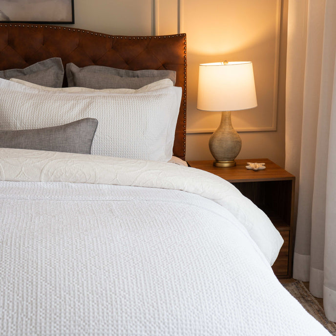 Quilt tipo waffle color blanco sobre cama, ideal para capas ligeras

