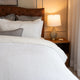 Quilt tipo waffle color blanco sobre cama, ideal para capas ligeras

