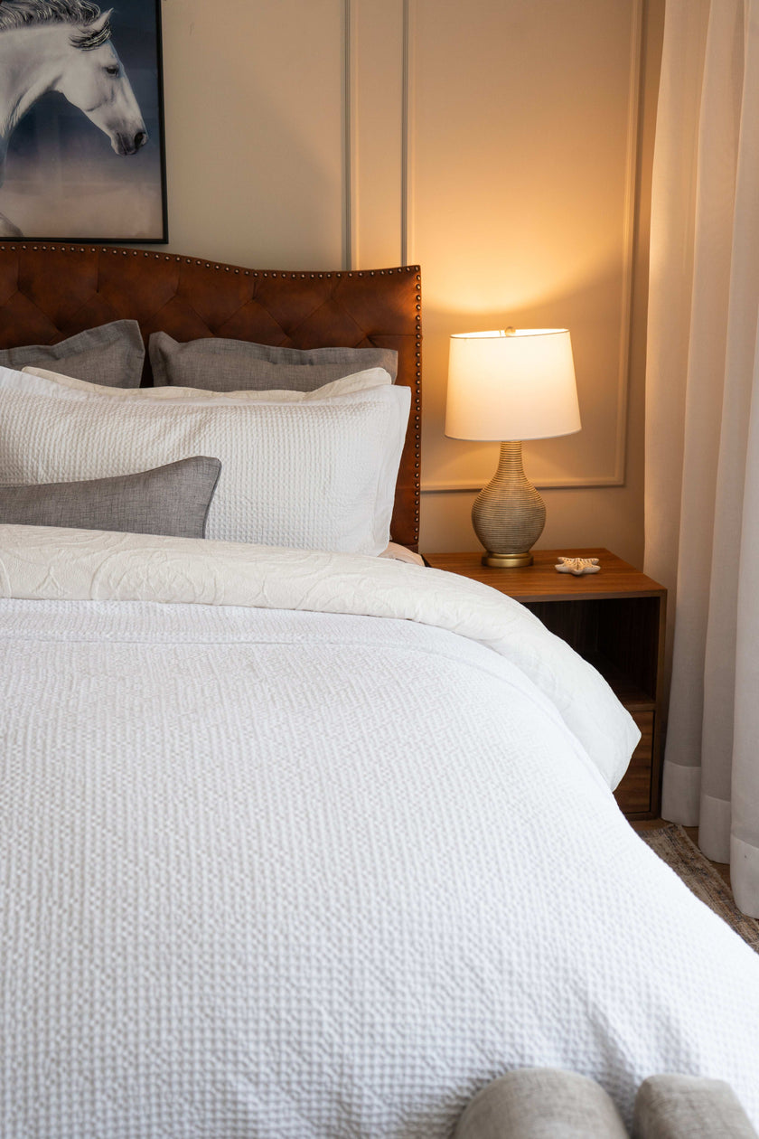 Quilt tipo waffle color blanco sobre cama, ideal para capas ligeras

