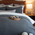 Quilt tipo waffle color gris sobre cama, ideal para capas ligeras
