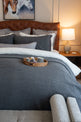 Quilt tipo waffle color gris sobre cama, ideal para capas ligeras
