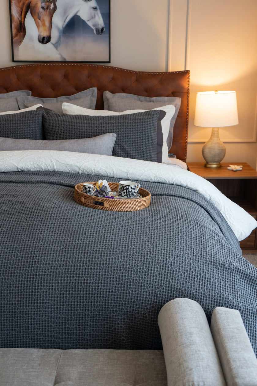 Quilt tipo waffle color gris sobre cama, ideal para capas ligeras