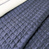 Quilt de satín color perla sobre cama, estilo elegante y brillante