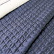 Quilt de satín color perla sobre cama, estilo elegante y brillante