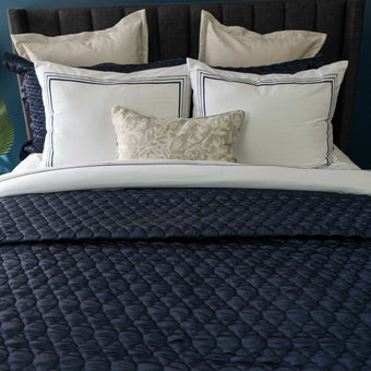 Quilt de satín color perla sobre cama, estilo elegante y brillante

