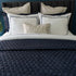 Quilt de satín color perla sobre cama, estilo elegante y brillante

